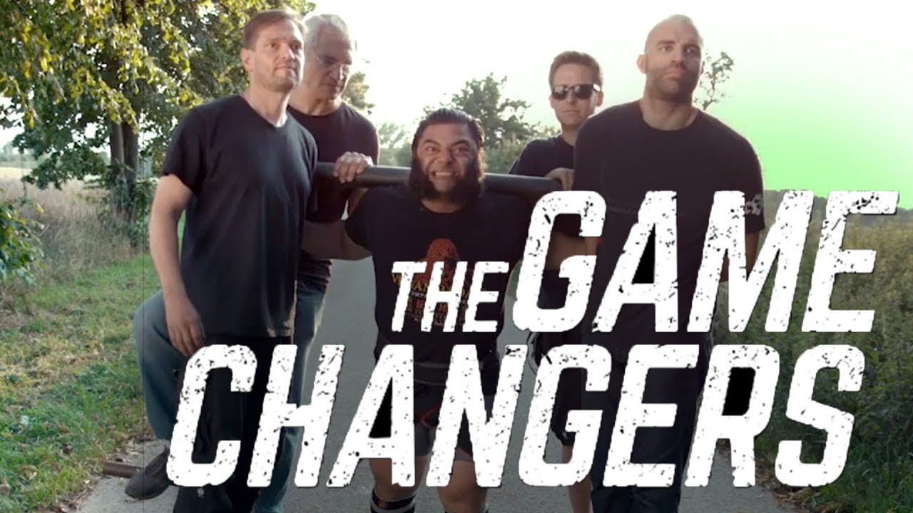 Movie poster with a vegan strongman lifting 4 men on a sled with the words the game changers